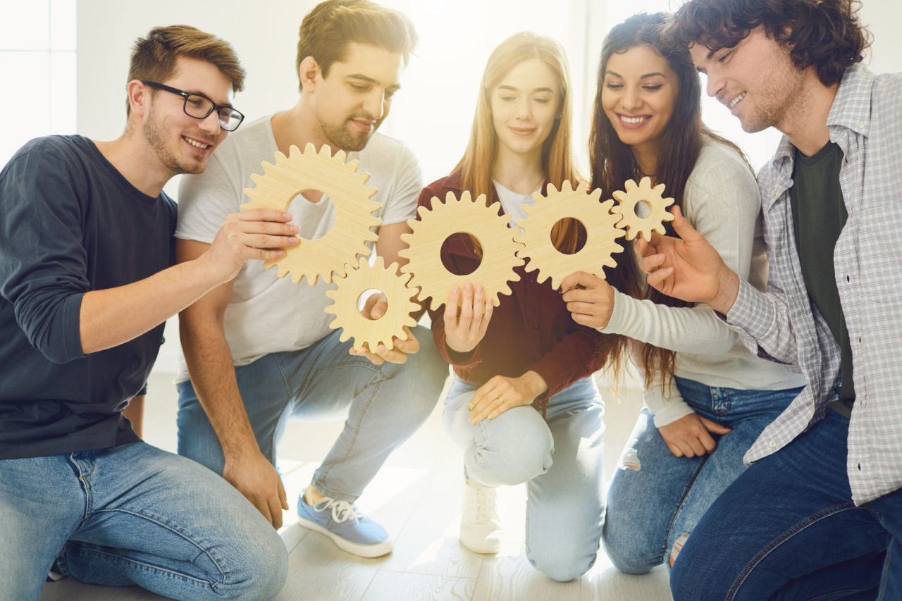 team members holding cogs that fit together