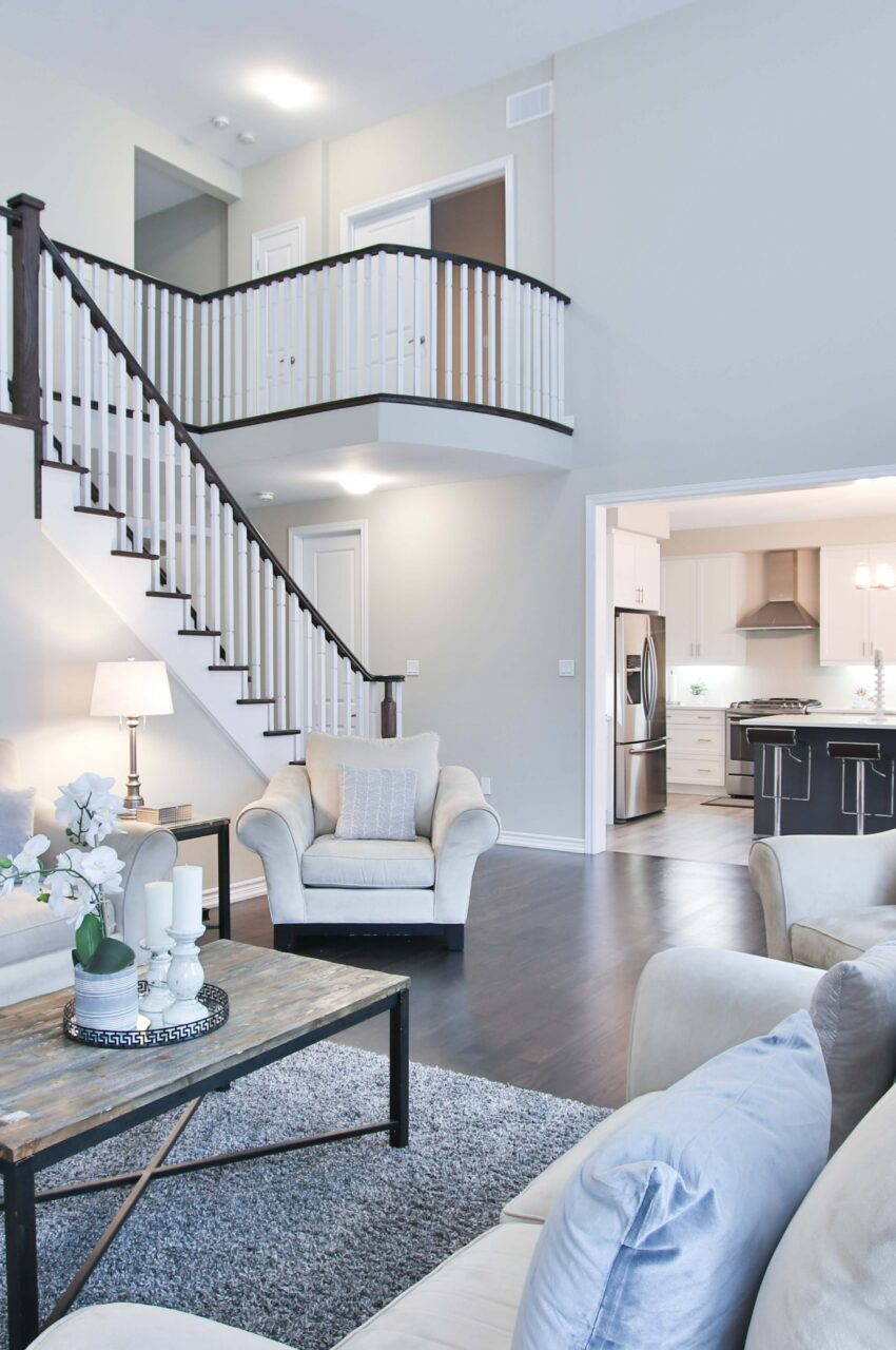 Living room with couches, coffee table and stairs with railing